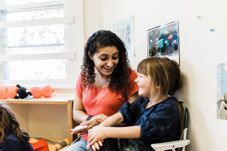 Dean College students talking to a child in the Children's Center