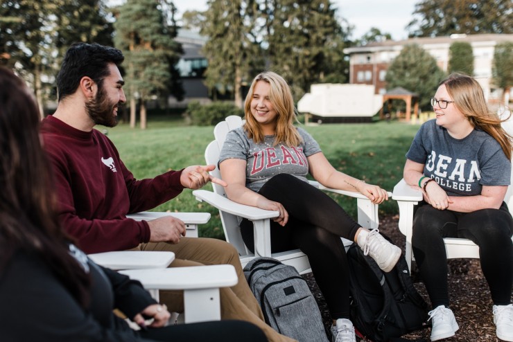 People chatting in white chairs