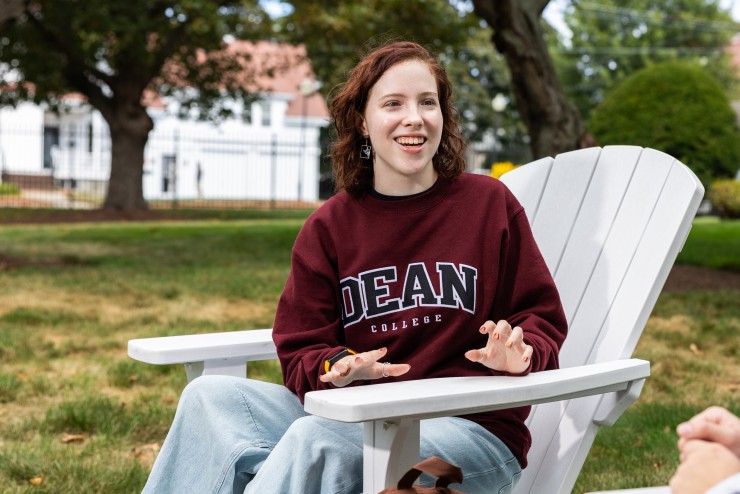 Student Wearing Maroon Dean Sweatshirt in Chair