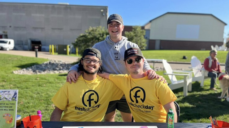 Three students at a table outside during Fresh Check Day