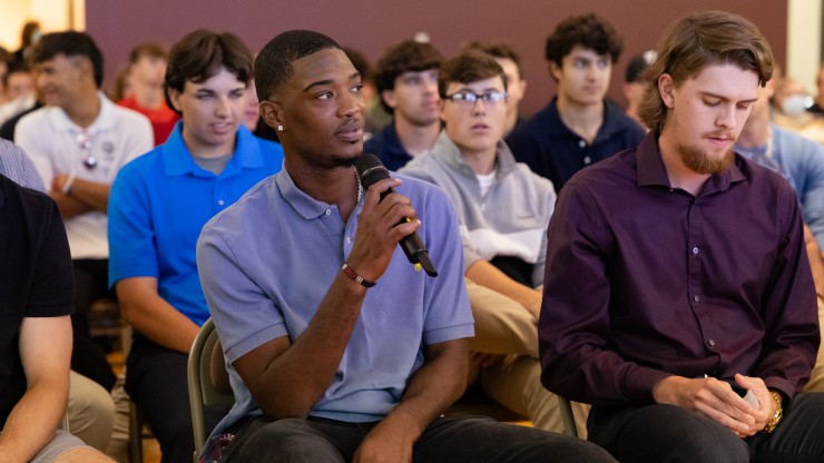 Dean college student in the audience asking Dr. Charles a question.